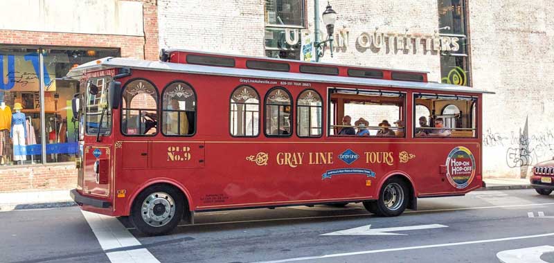 Gray Line Trolley driving down the road in downtown Asheville