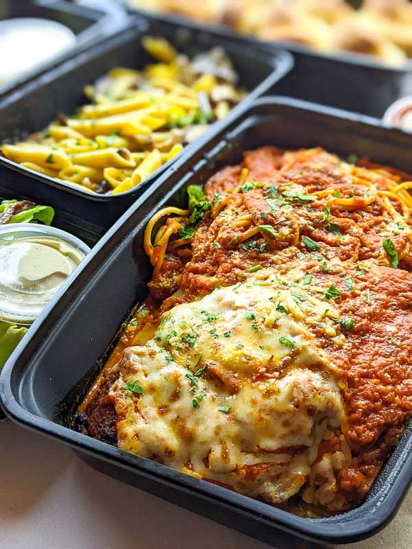 Chicken Parmigiana with spaghetti noodles in a takeout container from Asheville's Vinnie's Italian Restaurant