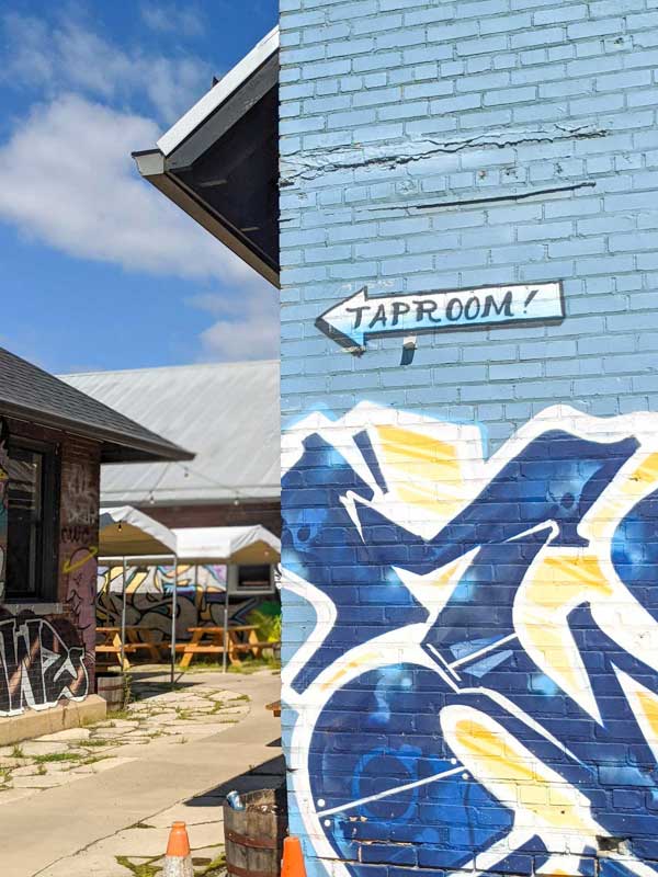 Sign showing taproom to the left on the side of the Wedge Brewery building in River Arts District