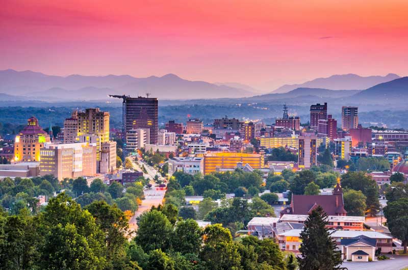 Downtown Asheville with Blue Ridge Mountains in the distance at sunset