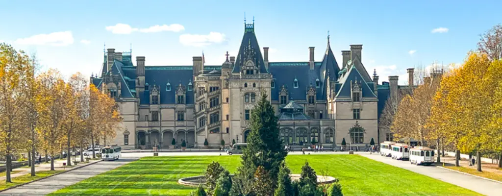 Exterior of the Biltmore Estate with Christmas trees on the lawn