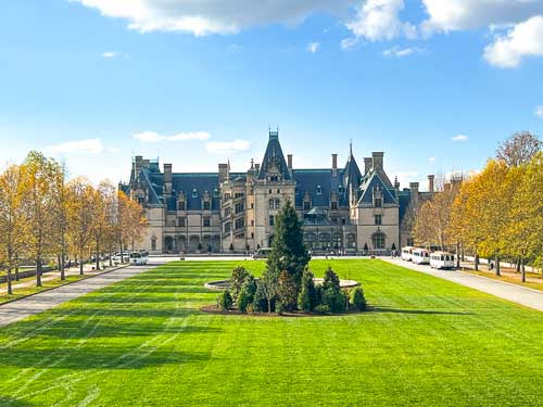 View of the Biltmore Estate with Christmas trees out front on a fall day