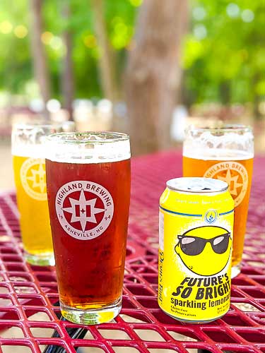 Beer and sparkling lemonade sitting on an outdoor table at Highland Brewing in Asheville