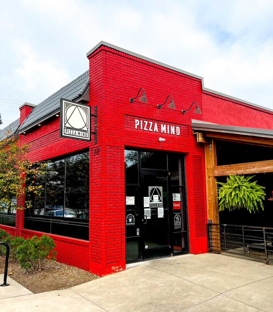 Red brick exterior of Pizza Mind in West Asheville