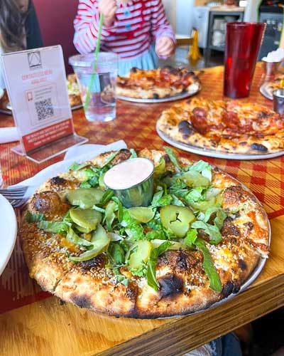 Happy Wheel pizza with special sauce, lettuce and pickles at Pizza Mind in West Asheville