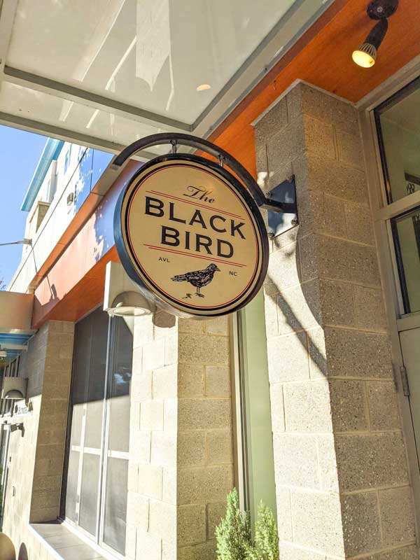Exterior sign of The Black Bird in downtown Asheville