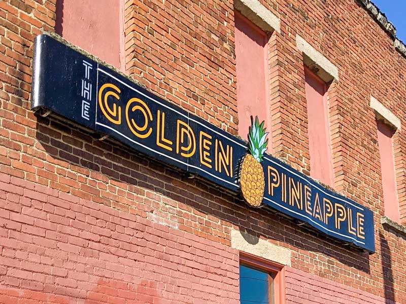 Exterior sign of The Golden Pineapple in West Asheville